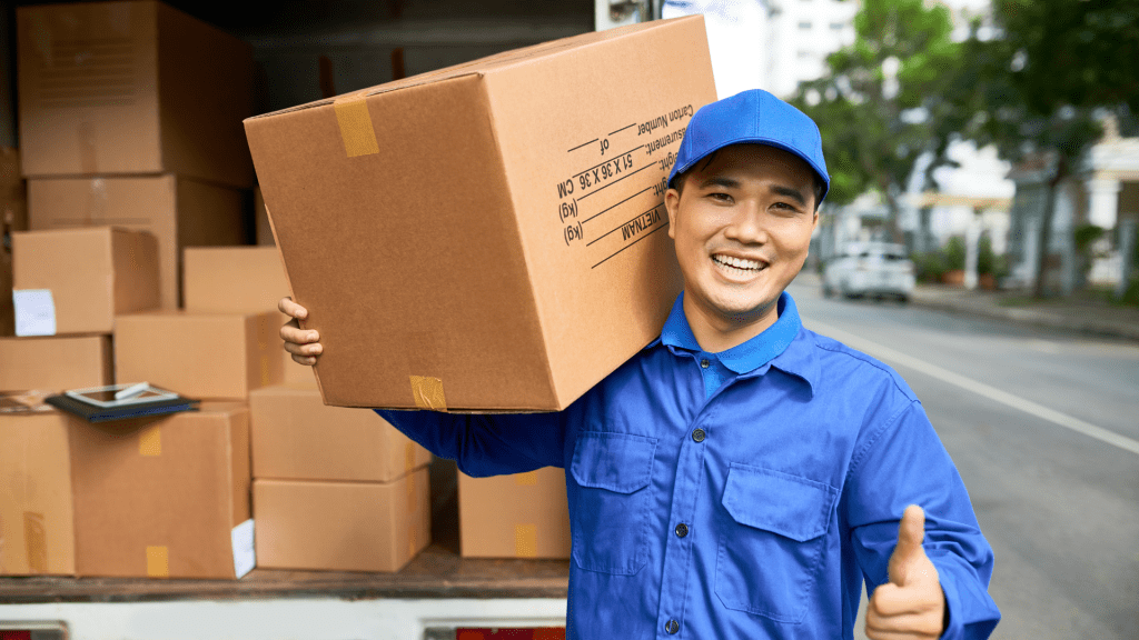 พนักงานจัดส่งในชุด ยูนิฟอร์มกำลังส่งมอบ กล่องพัสดุด้วยรอยยิ้ม
