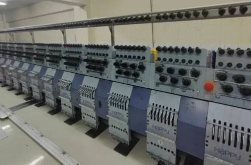 เครื่องจักรปัก HappyJapan หลายหัว มุมมองเฉียงจากฝั่งขวา เห็นหัวปักต่อเนื่อง